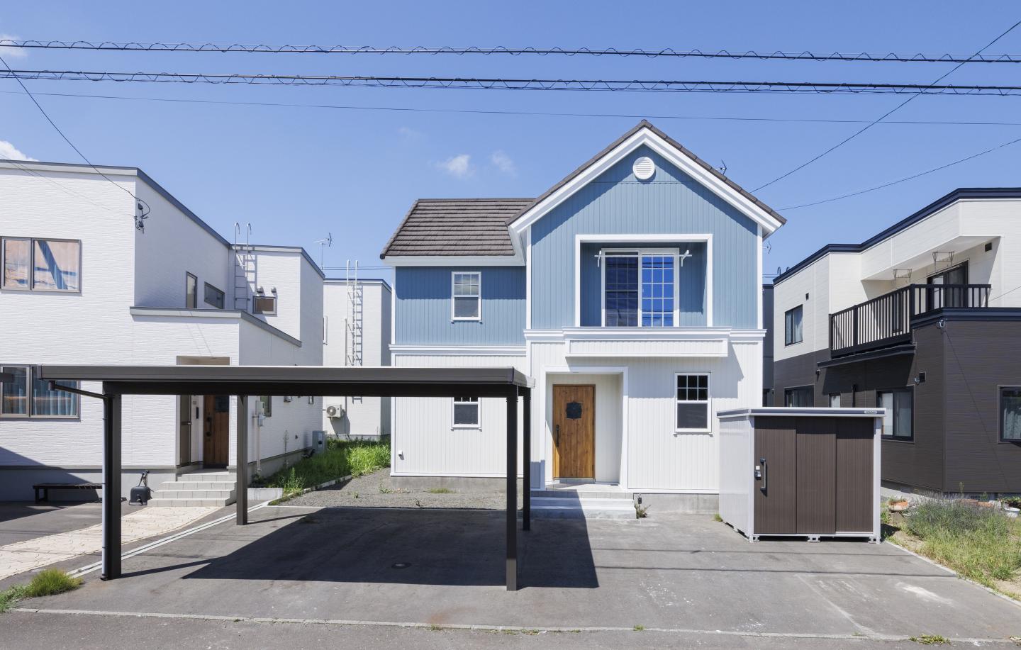 輸入住宅らしさはそのままに、外壁をブルーとホワイトに貼り分け、北欧調の外観へと一新。